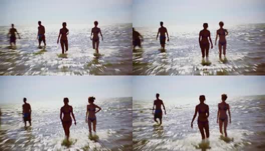 一群年轻的朋友在加拿大安大略省休伦湖的金沙海滩游泳和玩耍。签署金沙海滩。高清在线视频素材下载