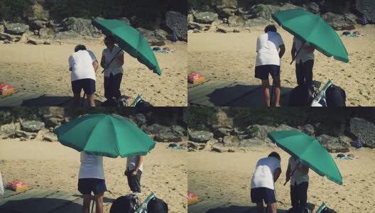 一对夫妇在搭沙滩伞高清在线视频素材下载