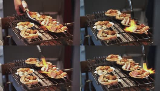 日本筑地市场的贝壳海鲜烧烤。厨师使用烧过的火炬高清在线视频素材下载