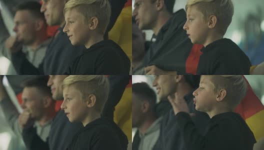 儿童和成人的德国球迷挥舞旗帜，在体育场为足球队欢呼高清在线视频素材下载