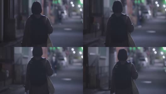 在冬天的晚上，年轻女子戴着防护面罩走在街上高清在线视频素材下载