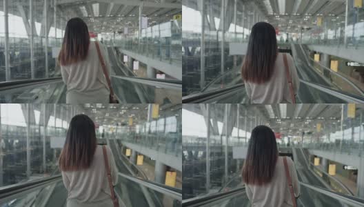 ์ื新常态od亚洲女性旅客在机场身穿粉色t恤，携带行李、护照和机票，戴着防COVID-19口罩，踏上新的旅程，旅行，度假，在自动扶梯上，后视镜高清在线视频素材下载
