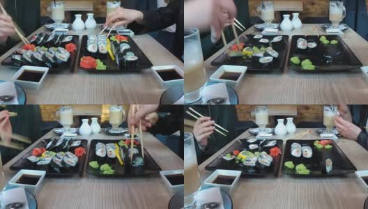一群人在一家餐馆里坐在一张时髦的桌子旁吃着寿司。时间流逝高清在线视频素材下载