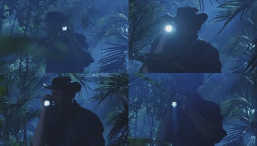 帽子冒险家在夜晚穿过丛林森林。使用手电筒高清在线视频素材下载
