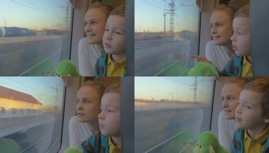 小男孩和妈妈坐在他们坐火车的地方，靠窗看着外面高清在线视频素材下载