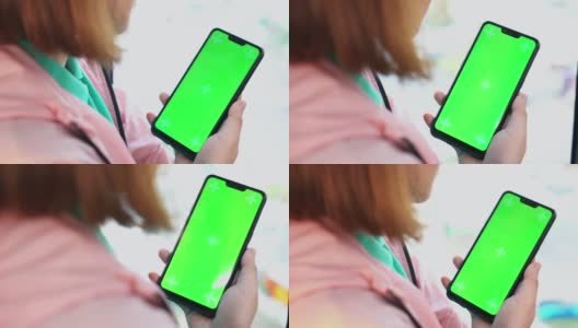 年轻女子在乘坐地铁时使用智能手机的特写，绿屏高清在线视频素材下载