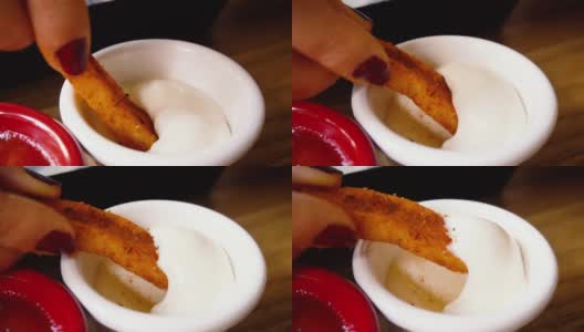 慢镜头:脆脆的薯条和蛋黄酱被人用手吃。高清在线视频素材下载