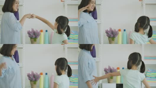 亚洲母亲和孩子洗衣服。妈妈和女儿有时间在家里一起打扫卫生。高清在线视频素材下载