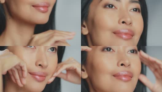 美丽的亚洲女人触摸她完美的脸。女性享受她的美丽，高自尊和健康。天然化妆品护肤品。提升孤立背景的特写肖像高清在线视频素材下载