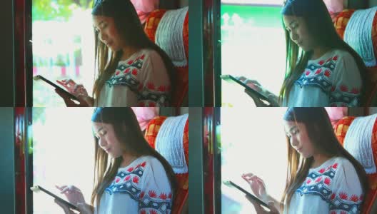 年轻的女商人在公交车上玩平板电脑。高清在线视频素材下载