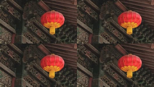 传统的红色中国灯笼挂着一个古老的雕刻和油漆木制建筑背景。高清在线视频素材下载