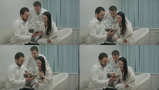 一组医生在医务室用平板电脑看一些有趣的东西高清在线视频素材下载