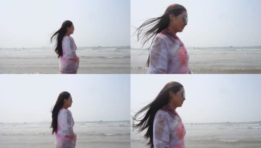 在海滩上围着围巾的女人高清在线视频素材下载