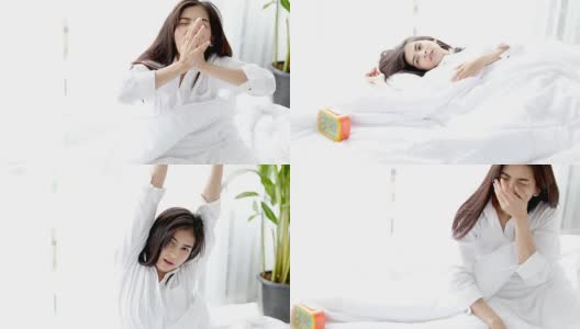 闹钟有一个美好的一天亚洲妇女醒来在她的床上充分休息，打开窗帘在早上得到新鲜空气。高清在线视频素材下载