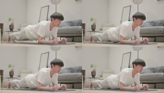 年轻的亚洲男子在瑜伽垫上做平板支撑高清在线视频素材下载