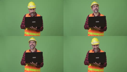 英俊的波斯胡须男建筑工人使用笔记本电脑高清在线视频素材下载