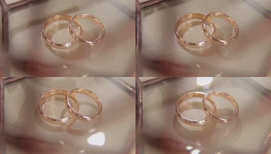 米色背景上的两个结婚戒指的特写。高清在线视频素材下载
