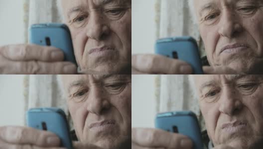 一位老人正在尝试使用一款带有触摸屏的新手机高清在线视频素材下载