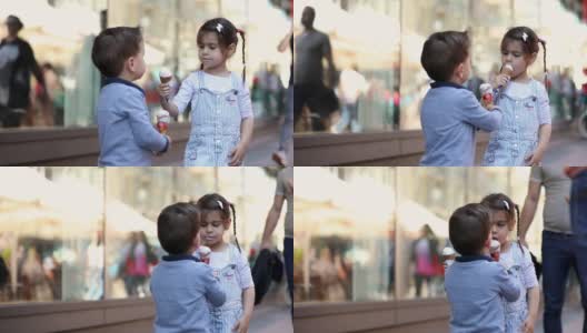 可爱的孩子们在购物中心前分享冰淇淋高清在线视频素材下载