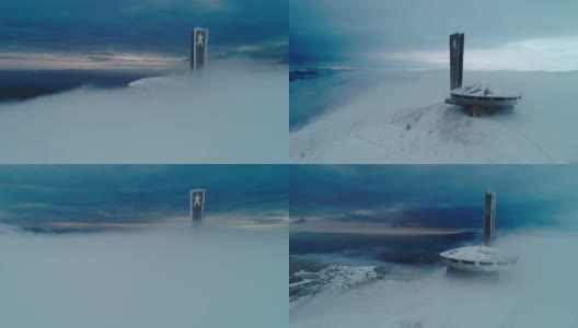 冬季鸟瞰图美丽，戏剧性，快速移动的云在雪山山顶，科幻的心情，嗡嗡扎纪念碑，不明飞行物。高清在线视频素材下载