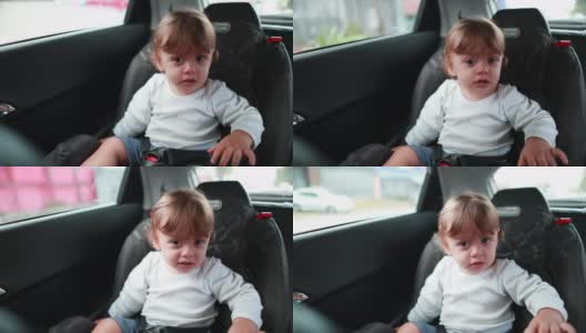 可爱的蹒跚学步的小男孩坐在汽车座椅上。儿童交通安全高清在线视频素材下载