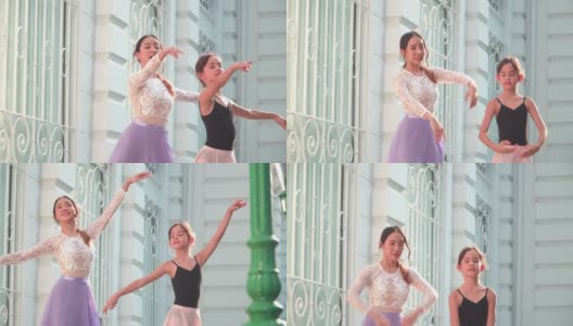 在一个阳光明媚的日子里，一名亚洲青少年芭蕾舞演员在一名年轻女芭蕾舞老师的建议下，在泰国曼谷当地的街道上练习芭蕾舞。活跃的年轻妇女和孩子的概念周末活动和当地地标。高清在线视频素材下载