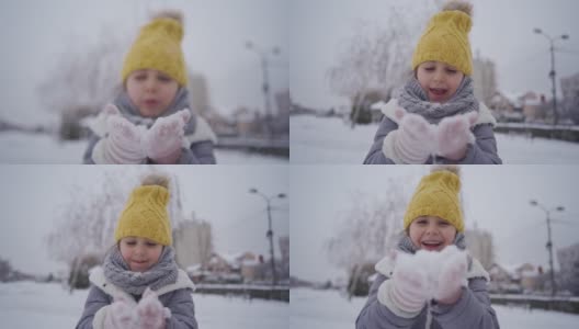 快乐的女孩从她的手掌吹雪高清在线视频素材下载