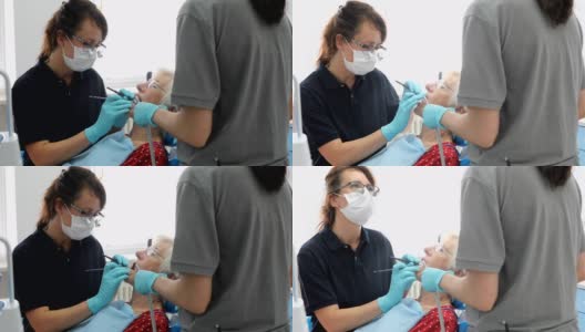 牙医正在检查一位老年妇女的牙齿高清在线视频素材下载