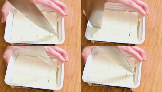 特写女性的手切豆腐奶酪塑料包装高清在线视频素材下载