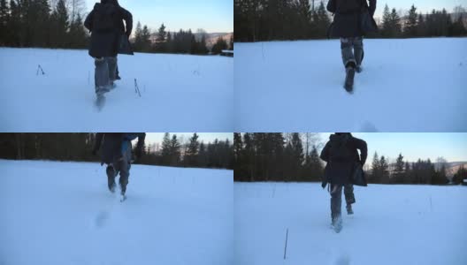 后视图，一个不认识的人慢跑通过雪地草坪在森林的边缘。年轻人晚上在雪地上奔跑，在冬季旅行中享受自由。特写慢动作高清在线视频素材下载