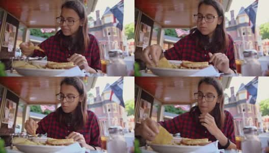 这位漂亮的16岁少女在宾夕法尼亚州波科诺斯地区吉姆·索普的街头咖啡馆里吃着莎莎酱和薯条高清在线视频素材下载