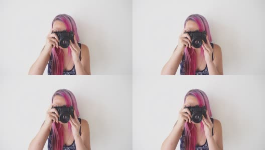 粉色头发的女孩用老式相机拍照高清在线视频素材下载
