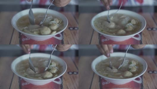 在街头小吃市场的餐桌上吃着肉丸和汤面高清在线视频素材下载