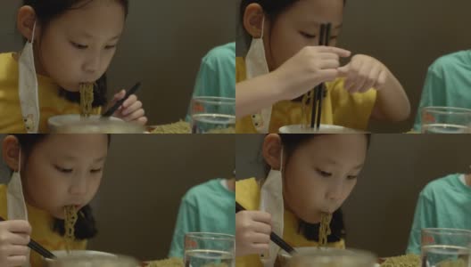 快乐的亚洲女孩与家人一起在餐厅吃面条、素喜烧、涮锅或火锅，生活方式理念。高清在线视频素材下载