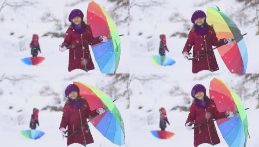 小女孩们在大雪中打着五颜六色的伞高清在线视频素材下载