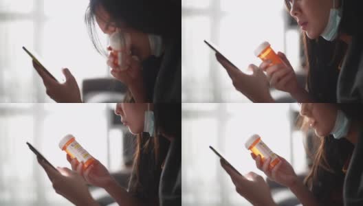 年轻的亚洲女性拿着药瓶，用着智能手机高清在线视频素材下载