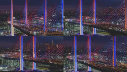 夜深时分，科修斯科大桥上的车流不断变换着颜色，背景是曼哈顿和布鲁克林的远处景色。航拍视频与宽阔的全景轨道摄像机运动。高清在线视频素材下载