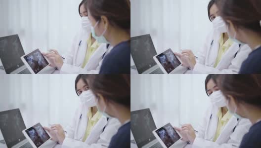 女医生一边讲解，一边给病人看片上的x光片。高清在线视频素材下载