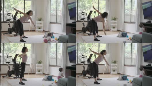 健康的妈妈在家锻炼，而她的宝宝在玩耍高清在线视频素材下载