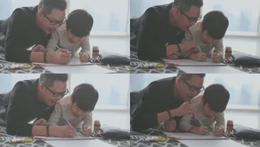 亚洲华人年轻的父亲和儿子周末在家里客厅公寓里画画，享受亲子时光高清在线视频素材下载