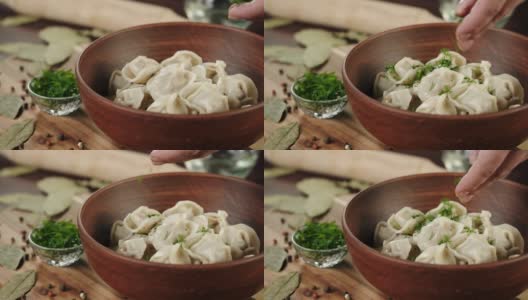 将绿叶小茴香洒在水饺上特写，用肉做面制品。传统的俄罗斯菜。木碗里的乌克兰食物。新鲜的菜高清在线视频素材下载