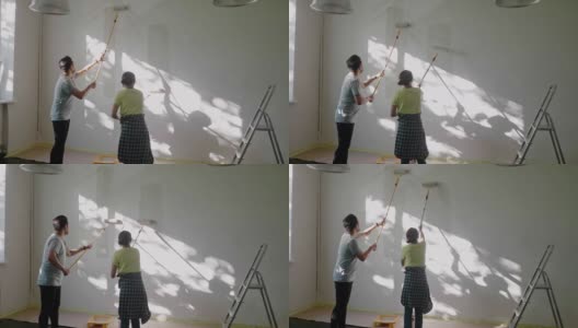日本夫妇用油漆滚筒在家里刷墙高清在线视频素材下载