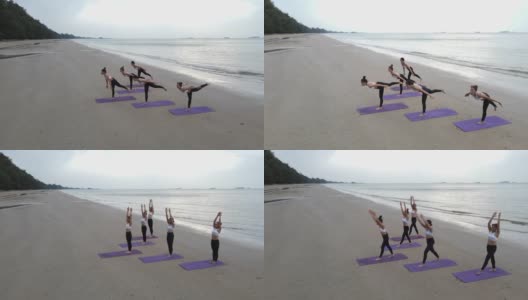鸟瞰图的团队身体战斗群做瑜伽在一个阳光灿烂的一天在海滩上。高清在线视频素材下载