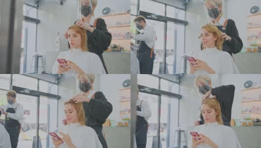 亚洲女性发型师在美容院为白人女性顾客的头发提供发型、发型和颜色建议。理发师戴口罩预防冠状病毒感染高清在线视频素材下载