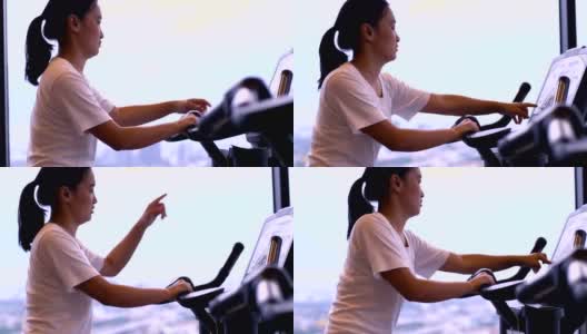 泰国女人与健身自行车在上午-股票视频高清在线视频素材下载