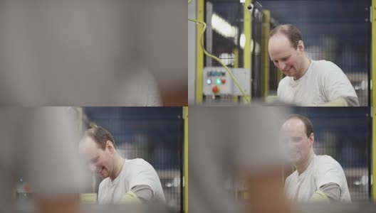 男员工微笑着在工厂里工作高清在线视频素材下载