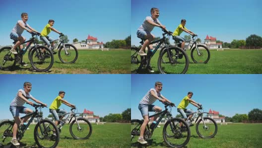 两个朋友一起骑自行车在绿色的草地上高清在线视频素材下载