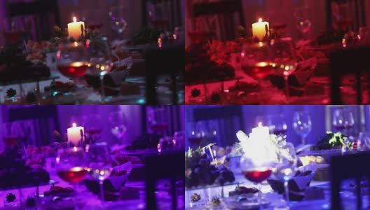 餐厅的宴会桌上放着玻璃杯和一支蜡烛，宴会桌上放着一杯红白葡萄酒，背景上放着一支燃烧的蜡烛，桌子上挂着一支装饰性的蜡烛高清在线视频素材下载