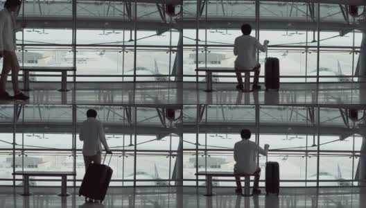 4 k。男性年轻乘客使用智能手机带着行李箱行走，坐在机场候机楼出发区的长凳上。正在出差的亚洲商人。现代旅游生活理念高清在线视频素材下载