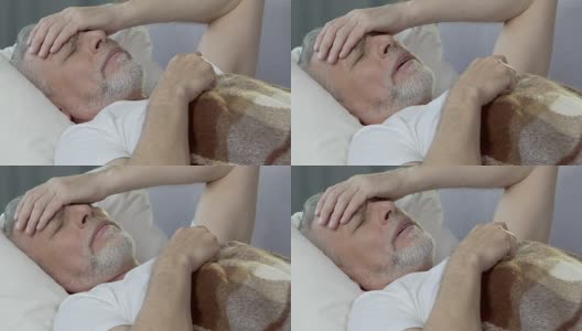 老人躺在床上睡不着，手捂着额头，头痛得厉害高清在线视频素材下载